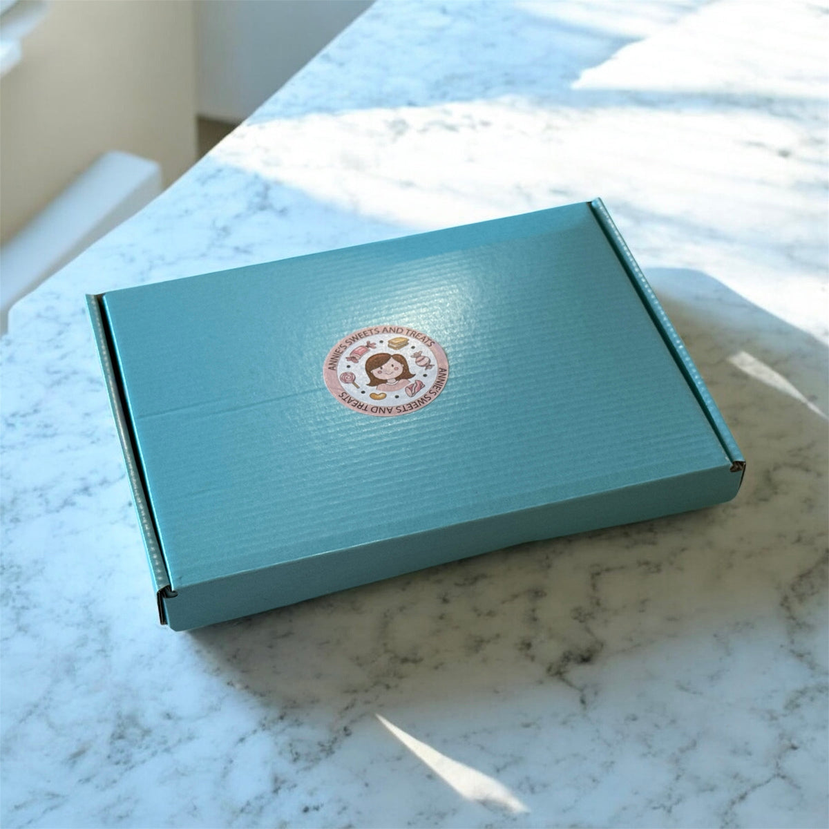 Light blue Annie’s gift box on a marble surface